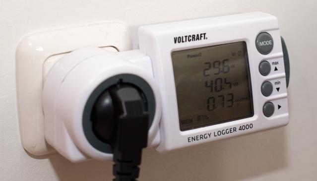 A watt meter measuring the power usage, showing 29.6W.